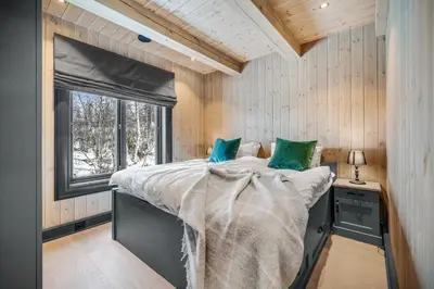 a bedroom with a large bed with a window at NEW LUXUARY Cabin with perfect location on Geilo. in Flatåker