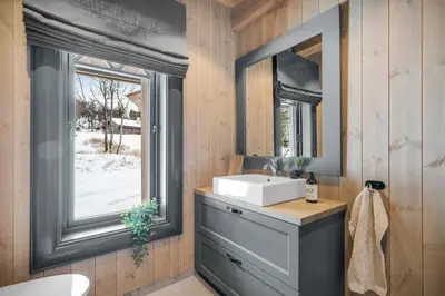 a bathroom with a sink and a mirror at NEW LUXUARY Cabin with perfect location on Geilo. in Flatåker
