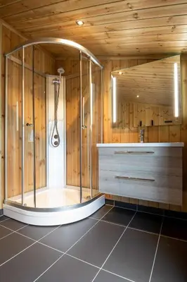 a shower in a bathroom with wooden walls at Gaustablikk Hytte - MountainView in Gaustablikk