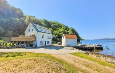 a house on the shore of a body of water at Nice Home In Fitjar With House Sea View in Fitjar