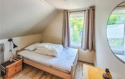 a small bed in a room with a window at Nice Home In Fitjar With House Sea View in Fitjar