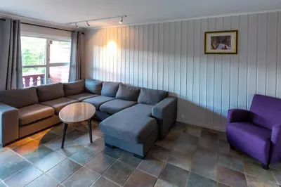 a living room with a couch and a chair at Bakkebyvegen 1D in Trysil