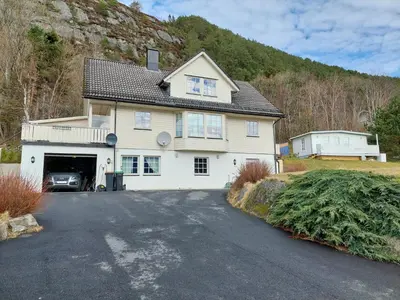 a large white house with a garage at Ålesund Apartment with free parking in Ålesund