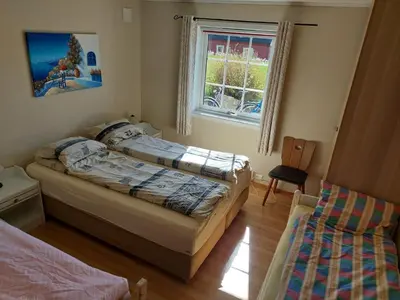a bedroom with two beds and a window at Ålesund Apartment with free parking in Ålesund
