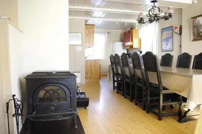 a room with a fireplace and a table and chairs at Svarteberg Drengestugu - cabin by Ål skisenter in Ål