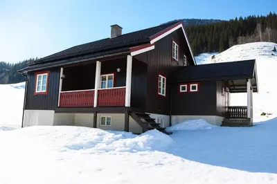 a black house in the snow with snow at Svarteberg Drengestugu - cabin by Ål skisenter in Ål