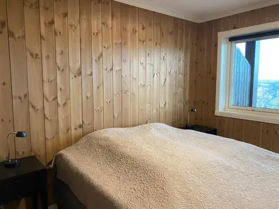 a bedroom with wooden walls and a bed and a window at ! Perfect Snow Condition! Beautiful Apartment at Skagahøgdi with Panoramic View in Gol