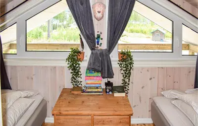 a small room with a table and two windows at Cozy Home In Brøttum With Kitchen