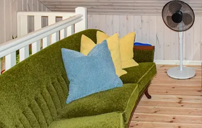 a green couch with yellow and blue pillows on it at Cozy Home In Brøttum With Kitchen