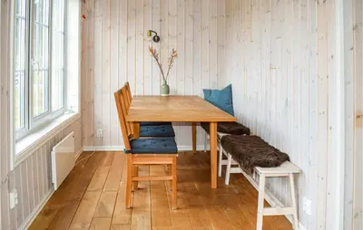 a wooden table and chairs in a room at Cozy Home In Brøttum With Kitchen