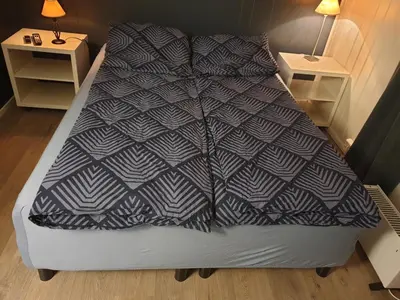 a large bed in a room with two night stands at Holiday Rooms in Gol