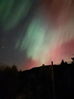 an aurora in the sky over a fence at Holiday Rooms in Gol