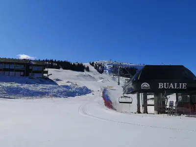 a snow covered slope with a building and a ski lift at Koselig leilighet med ski in ski out på Golsfjellet in Gol
