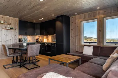 a living room with a couch and a table at Koselig leilighet med ski in ski out på Golsfjellet in Gol