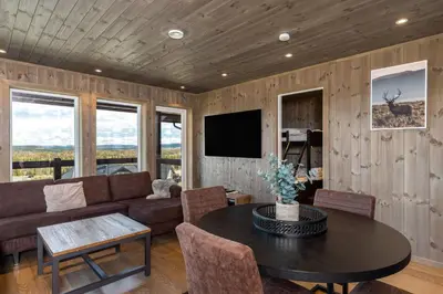 a living room with a couch and a table at Koselig leilighet med ski in ski out på Golsfjellet in Gol
