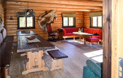 a room with a table and chairs in a log cabin at Låven in Rauland
