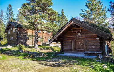 a log cabin with a grass roof and a door at Låven in Rauland
