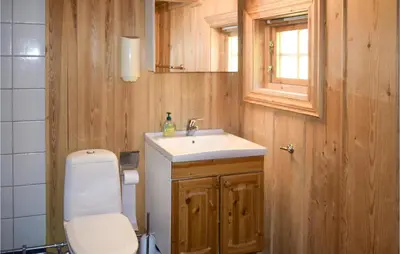 a bathroom with a toilet and a sink and a window at Stallen 2 in Rauland