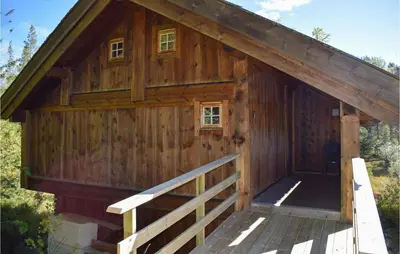 a large wooden cabin with a porch and a fence at Stallen 2 in Rauland