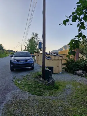a blue car parked on the side of a road at Stranda apartment in Stranda