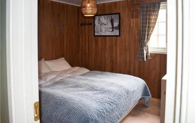 a bedroom with a bed with a wooden wall at Nice Home In Rjukan With Wifi in Rjukan