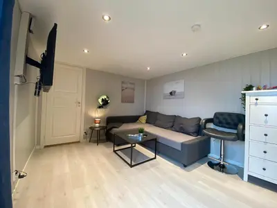 a living room with a couch and a table at Landlig beliggenhet med flott utsikt over Mjøsa in Ulven