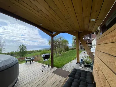 a wooden deck with a grill and a bench on it at Landlig beliggenhet med flott utsikt over Mjøsa in Ulven