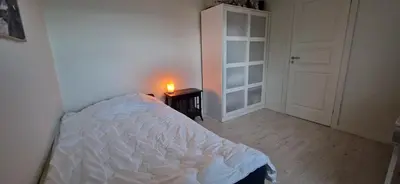a bedroom with a bed and a candle on a table at Relaxing place on Godøya in Godøy