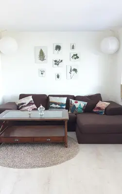 a living room with a brown couch and a coffee table at Relaxing place on Godøya in Godøy