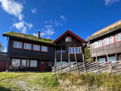 a large wooden house with a grass roof at Bjødnabakkens fjellutsikt in Beitostøl