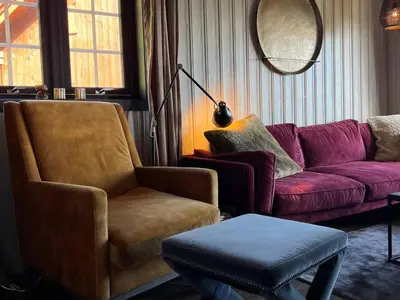 a living room with a couch and a chair at Bjødnabakkens fjellutsikt in Beitostøl