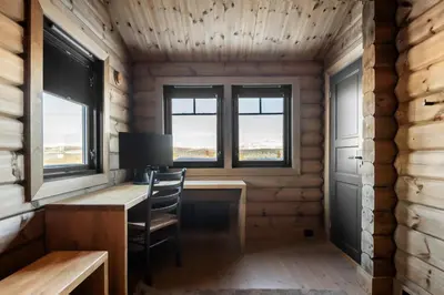 an office in a log cabin with a desk and two windows at Trysilsetra 35 in Trysil