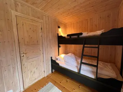 a room with two bunk beds in a wooden cabin at Stadionutsikten in Beitostøl