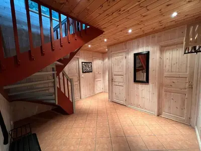 a hallway with a staircase in a home with wooden walls at Stadionutsikten in Beitostøl