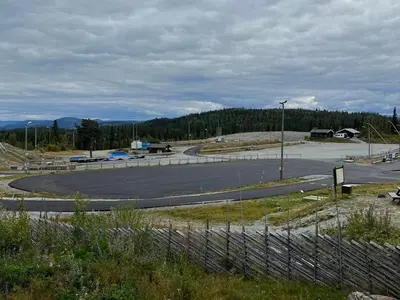 an empty parking lot with a road and trees at Stadionutsikten in Beitostøl