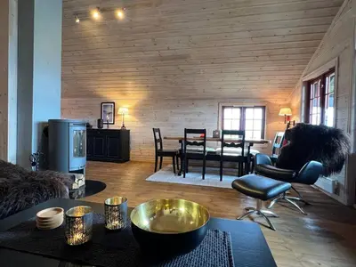 a living room with a table and a dining room at Stadionutsikten in Beitostøl