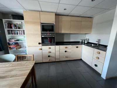 a large kitchen with wooden cabinets and a table at Spacious 2-bedroom holiday apartment - Hemsedal Veslehorn 14 in Hemsedal