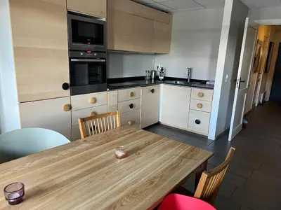 a kitchen with a wooden table with chairs and a kitchen at Spacious 2-bedroom holiday apartment - Hemsedal Veslehorn 14 in Hemsedal