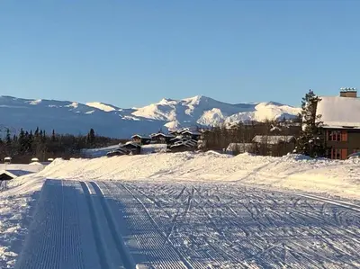 a snow covered ski slope with snow covered mountains at Beitotind sentralt på Beitostølen in Beitostøl