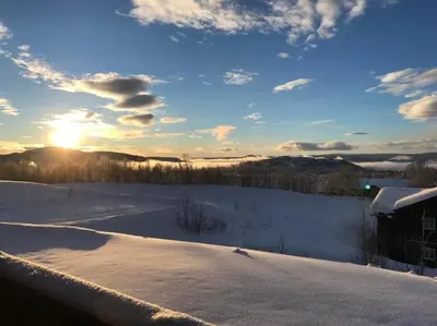 a snow covered field with the sun in the sky at Beitotind sentralt på Beitostølen in Beitostøl