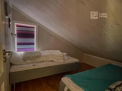 an attic room with a bed and a window at Family friendly cabin Hemsedal GolfAlpin golf, ski-out, fireplace & wifi in Hemsedal