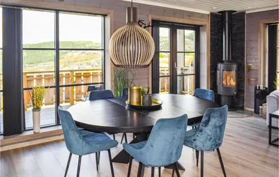 a dining room with a wooden table and blue chairs at Stunning Home In Rauland With Sauna in Rauland