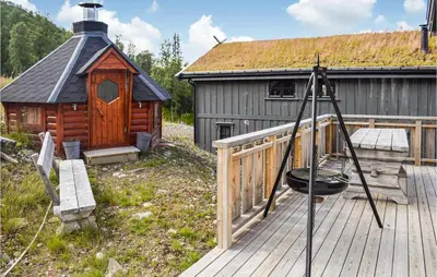 a wooden deck with a cabin with a black roof at Stunning Home In Rauland With Sauna in Rauland