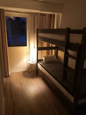a bedroom with a bunk bed with a lamp and a window at Bjorli Apartment 203 (200m til Skitrekk) in Bjorli