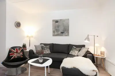 a living room with a black couch and a chair at Bjorli Apartment 203 (200m til Skitrekk) in Bjorli