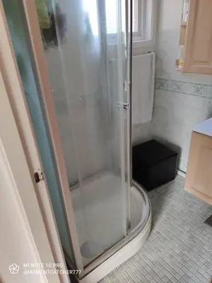 a shower with a glass door in a bathroom at Guest room in private house in Ålesund