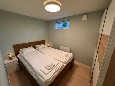 a small bedroom with a bed with white sheets at Fjord studio in Sunde
