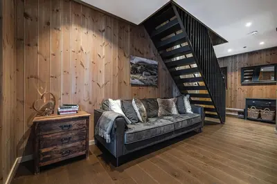 a living room with a couch and a staircase at Fyri Tunet Hemsedal in Hemsedal