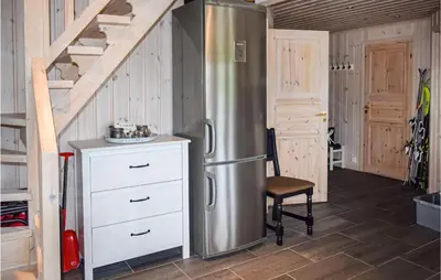 a stainless steel refrigerator in a kitchen with a staircase at Cozy Home In Rjukan With Kitchen in Rjukan
