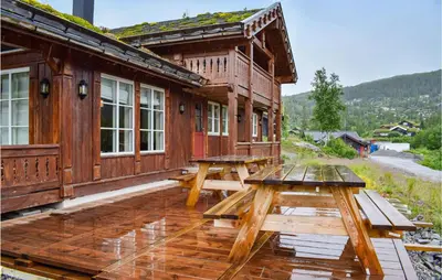 a wooden cabin with picnic tables on a deck at Cozy Home In Rjukan With Kitchen in Rjukan